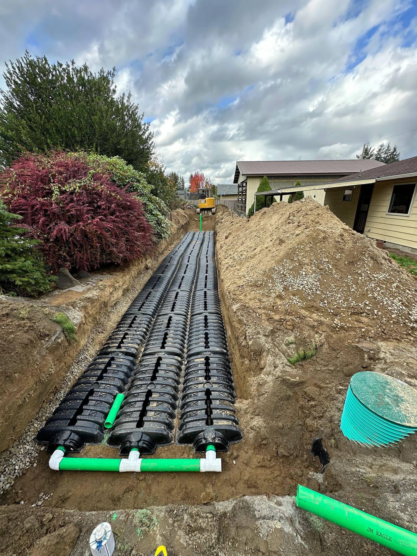 Drainfield chamber rows laid in an open trench before backfill.
