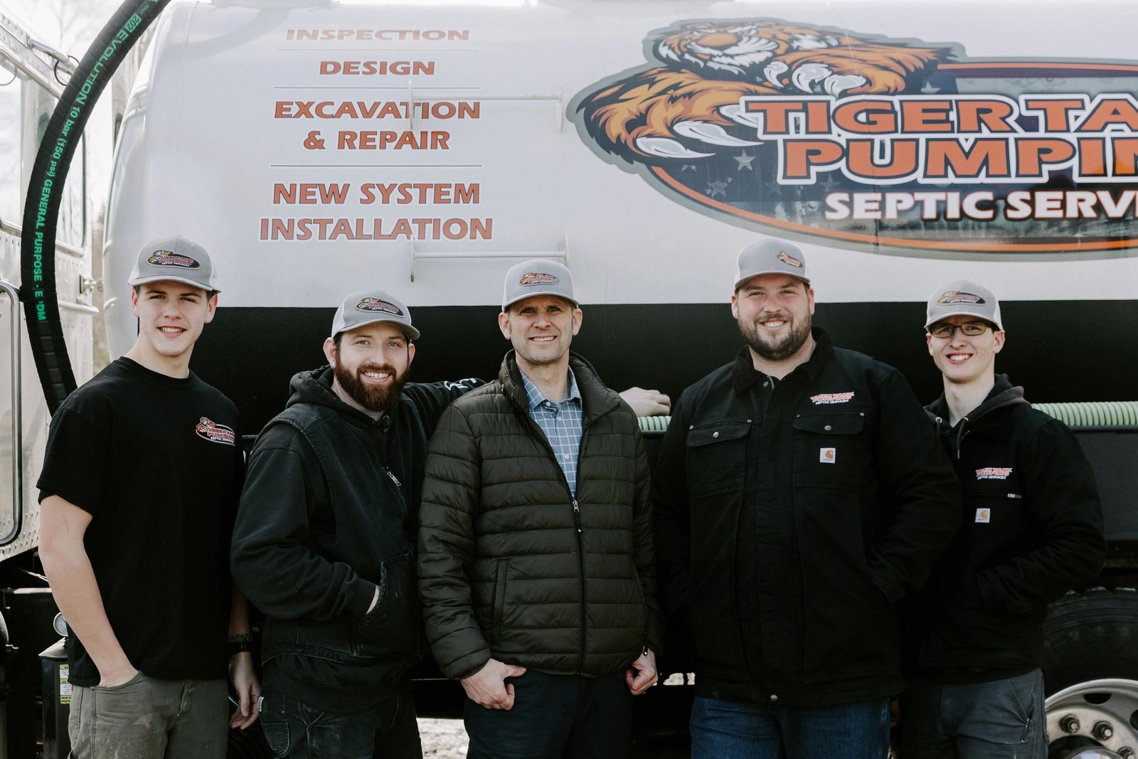 The five-man Tiger Tank Pumping crew standing together in front of the pump truck.